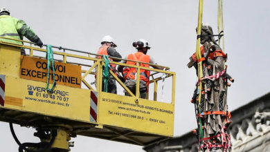 Des ouvriers prennent des mesures de protection pour une statue à Notre-Dame le 29 avril. © KENZO TRIBOUILLARD / AFP